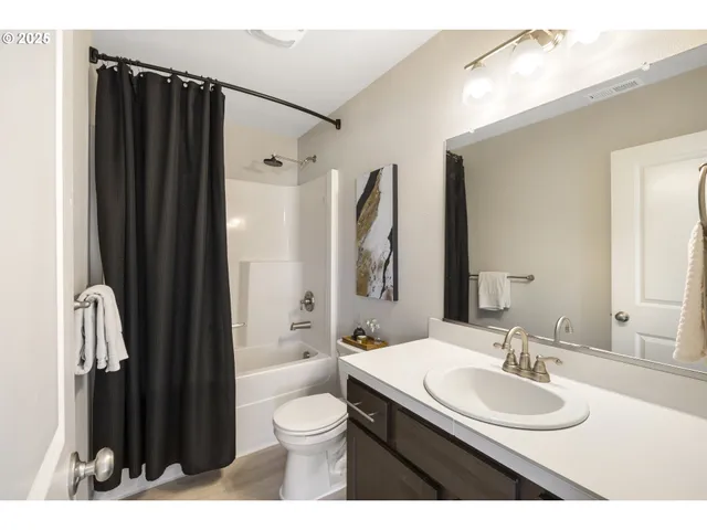 a bathroom with a sink a toilet a mirror and shower