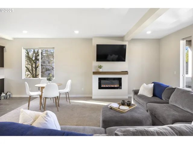 a living room with furniture a flat screen tv and a fireplace