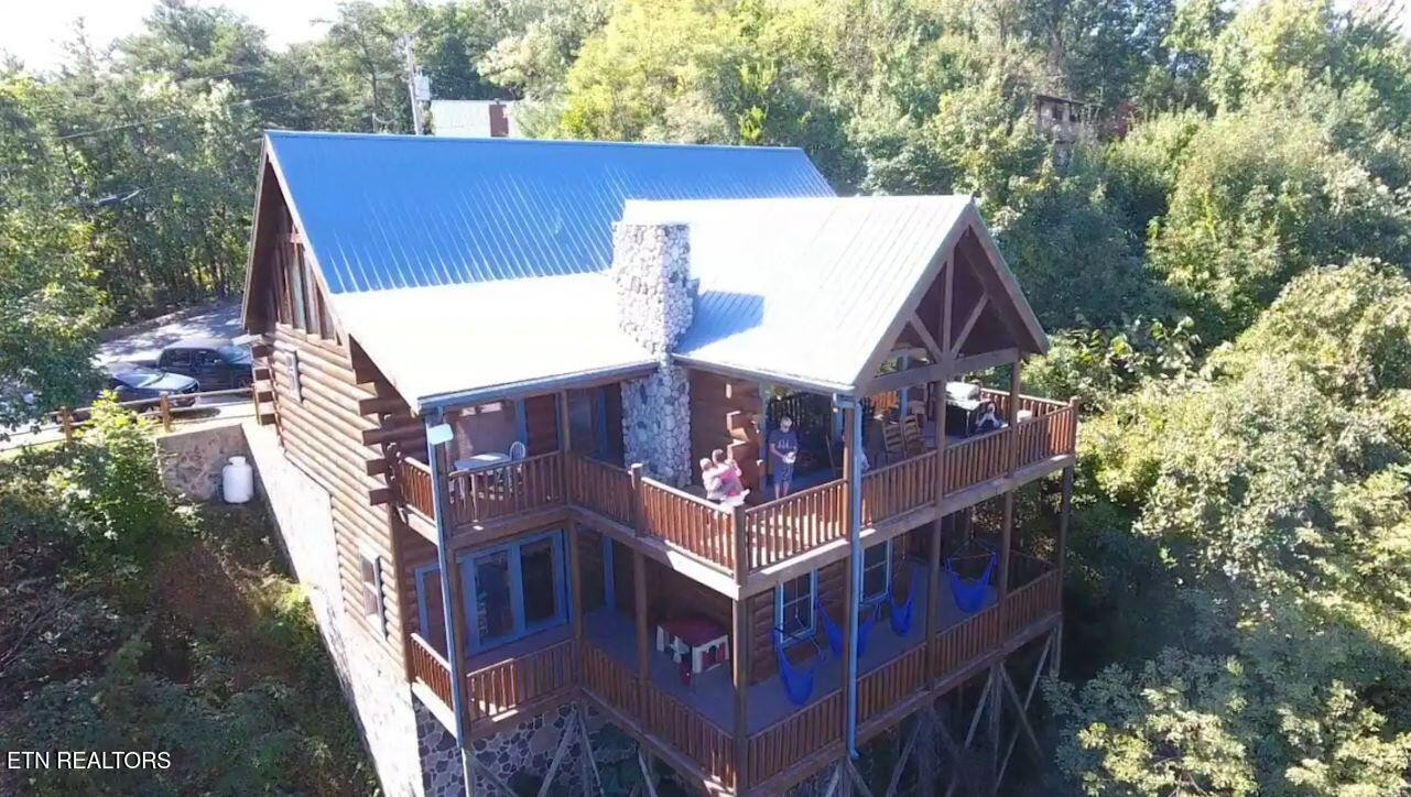 aerial view of a house with a yard and large trees
