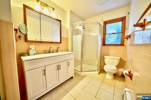 a bathroom with a granite countertop sink mirror and a toilet