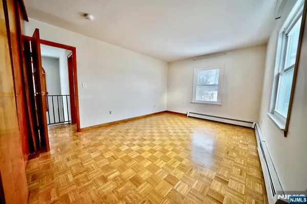 a view of an empty room with window and a bathroom