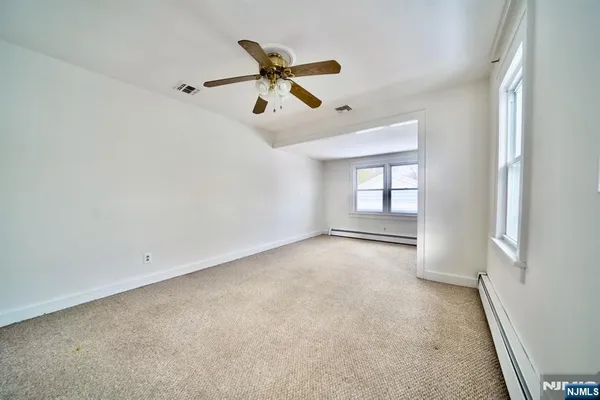 a view of a livingroom with a ceiling fan and window
