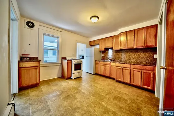 a kitchen with granite countertop a sink cabinets and stainless steel appliances