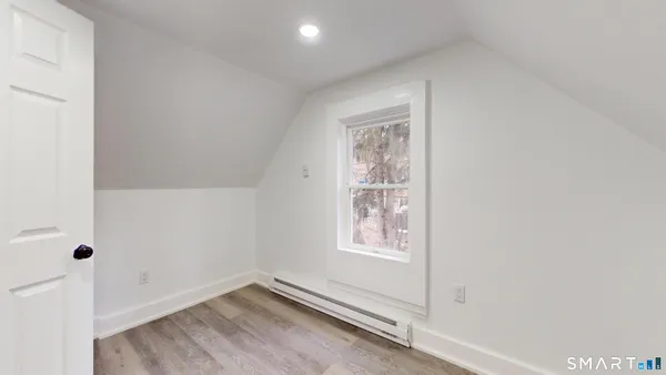 an empty room with wooden floor and window