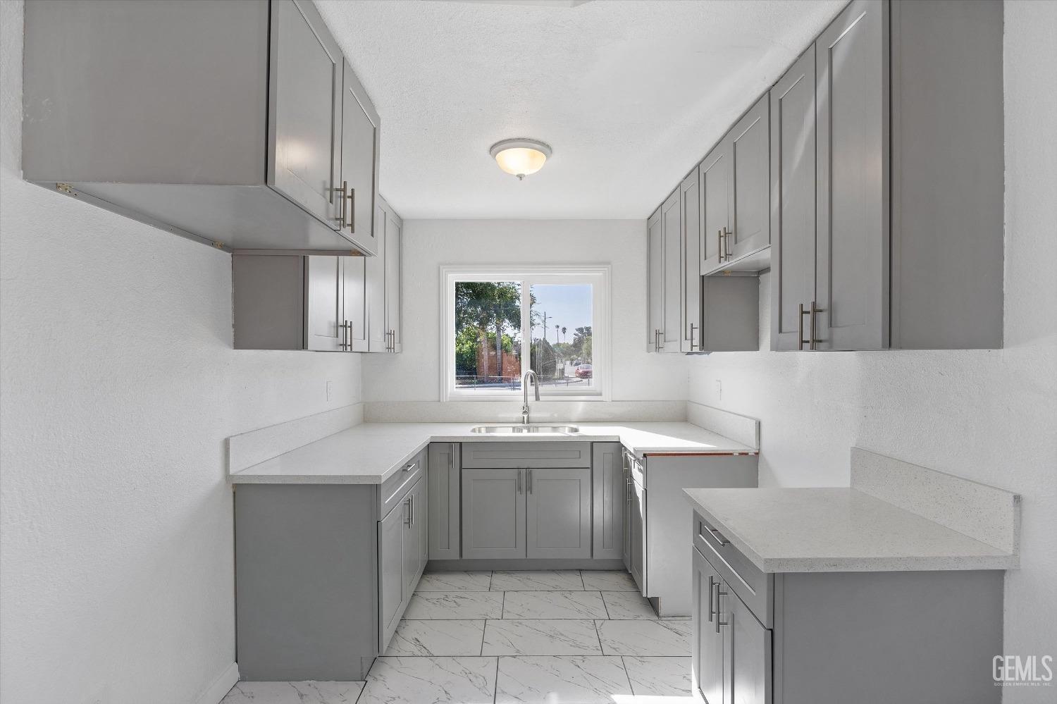 Undisclosed Address Bakersfield, CA 93306 - Photo 12 of 26 a kitchen with a sink dishwasher a stove and cabinets