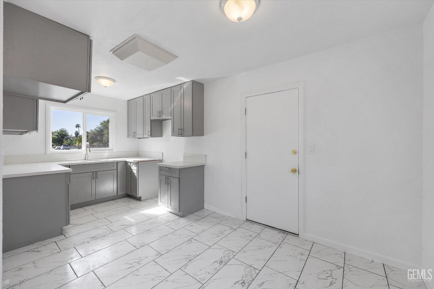 Undisclosed Address Bakersfield, CA 93306 - Photo 14 of 26 a large white kitchen with cabinets and stainless steel appliances