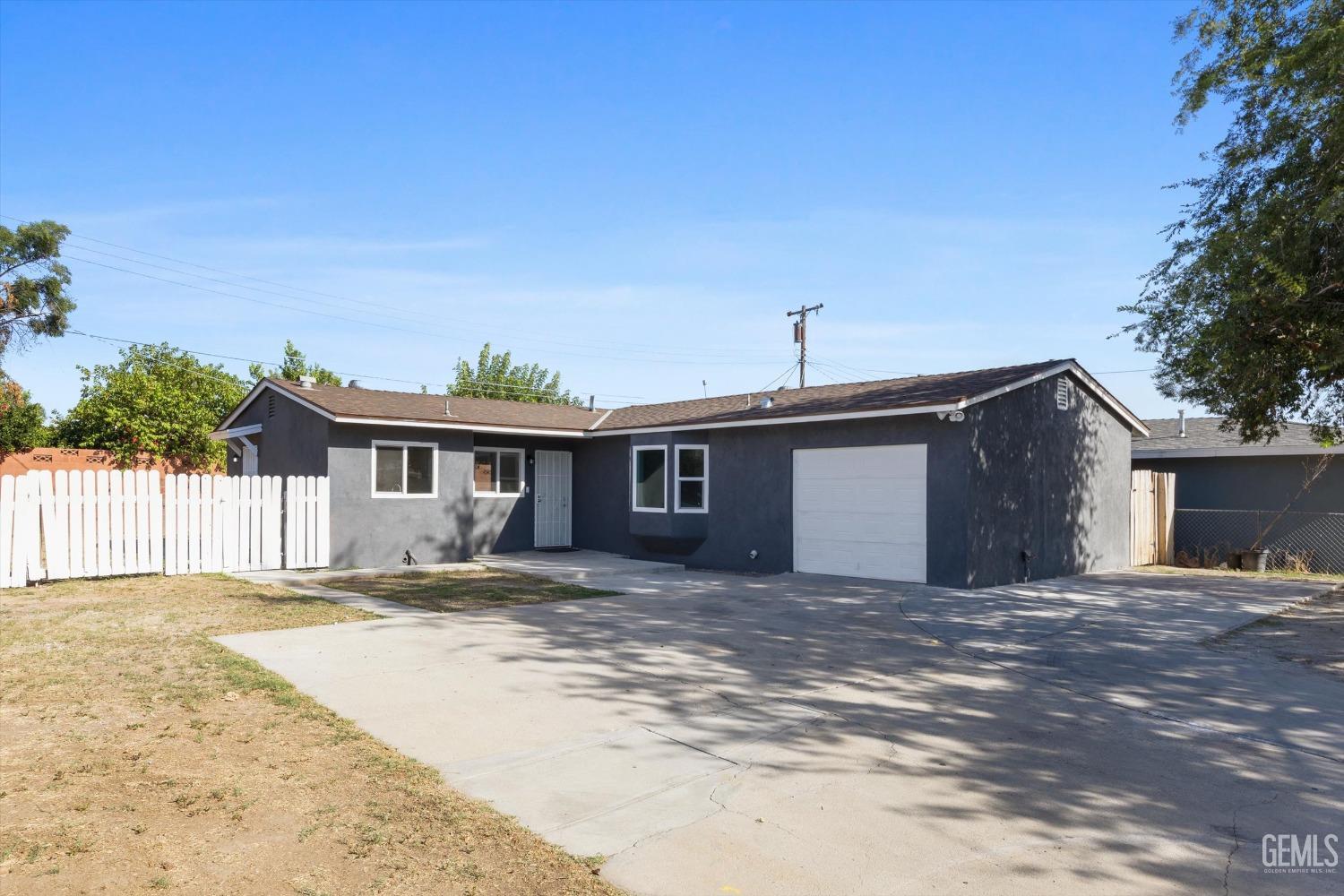 Undisclosed Address Bakersfield, CA 93306 - Photo 4 of 26 a house that has a big yard and large trees