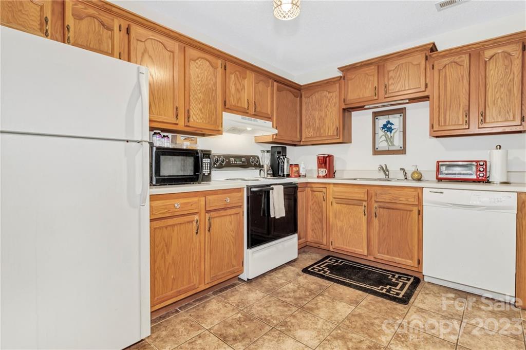11 Krista Circle, Unit E Candler, NC 28715 - Photo 15 of 25 a kitchen with stainless steel appliances a refrigerator sink and cabinets