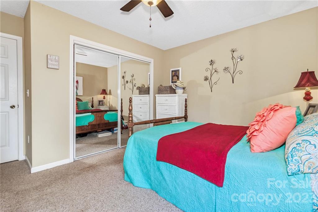 11 Krista Circle, Unit E Candler, NC 28715 - Photo 20 of 25 a bedroom with a bed and a chandelier