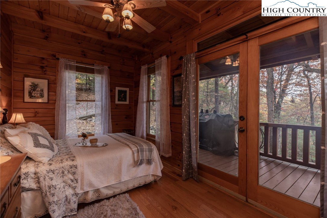 899 Bobcat Mountain Road Purlear, NC 28665 - Photo 22 of 50 a bedroom with a large bed and a chandelier