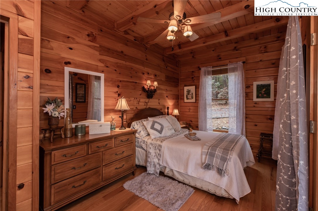 899 Bobcat Mountain Road Purlear, NC 28665 - Photo 24 of 50 a bedroom with a bed and a chandelier
