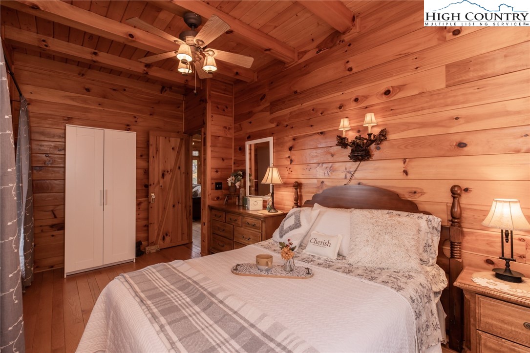 899 Bobcat Mountain Road Purlear, NC 28665 - Photo 25 of 50 a bedroom with a bed and a chandelier