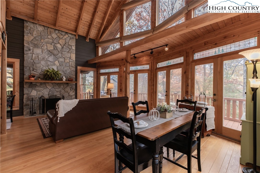 899 Bobcat Mountain Road Purlear, NC 28665 - Photo 7 of 50 a view of a dining room with furniture large windows and wooden floor