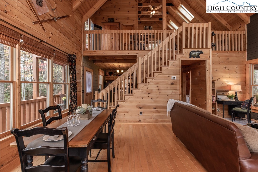 899 Bobcat Mountain Road Purlear, NC 28665 - Photo 10 of 50 a view of a livingroom with furniture stairs wooden floor and windows