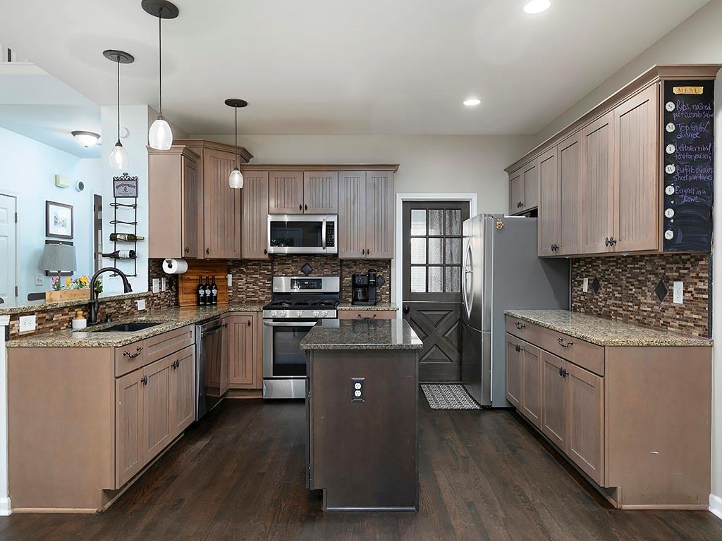 117 Constitution Pointe Dallas, GA 30132 - Photo 13 of 50 a kitchen with stainless steel appliances kitchen island granite countertop a stove a sink a refrigerator a center island and cabinets