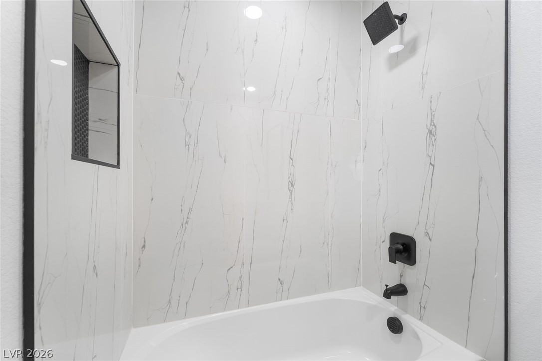 39 Lowery Street Henderson, NV 89015 - Photo 31 of 40 Clean lines define this bathroom's sophisticated shower and tub combination, featuring sleek tile and modern fixtures.