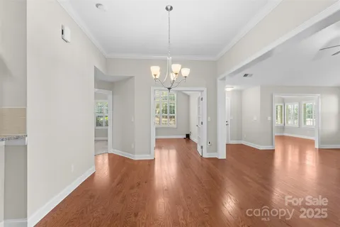 a view of an empty room with wooden floor and windows