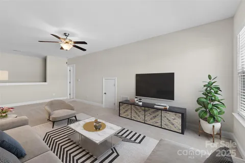 a view of an empty room with a chandelier fan