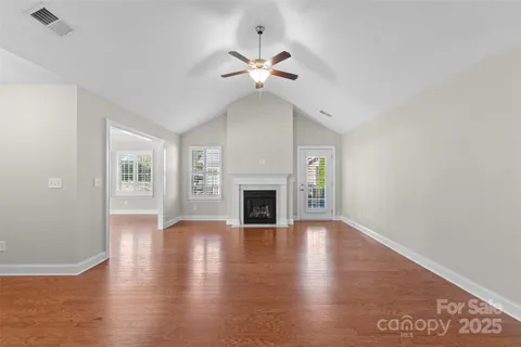 a view of a livingroom with wooden floor and a fireplace