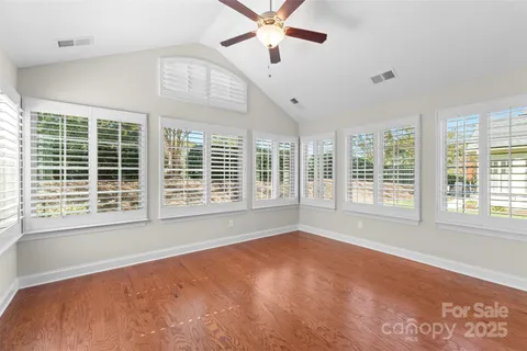a view of an empty room with a window and a kitchen
