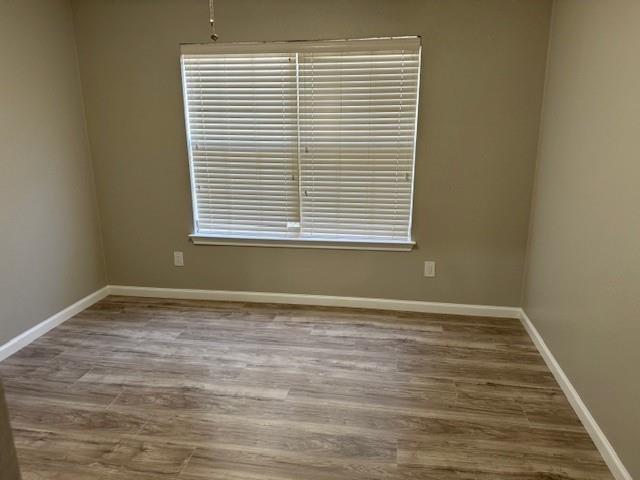 2700 Whetstone Drive Corinth, TX 76210 - Photo 7 of 12 a view of an empty room with wooden floor and a window