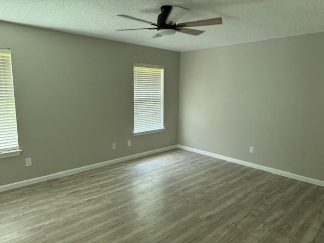 2700 Whetstone Drive Corinth, TX 76210 - Photo 9 of 12 an empty room with wooden floor fan and windows