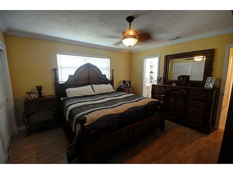 4441 Northeast 22nd Avenue Lighthouse Point, FL 33064 - Photo 10 of 18 a bedroom with a bed and a chandelier