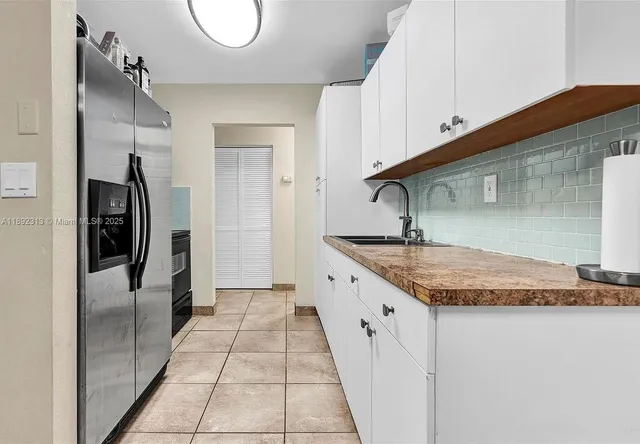 a kitchen with stainless steel appliances granite countertop a sink and a refrigerator