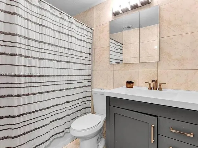 a bathroom with a sink toilet and mirror