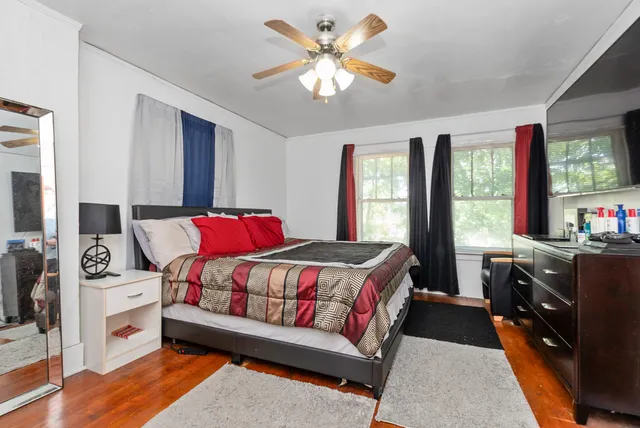 a bedroom with a bed and a dresser next to a window
