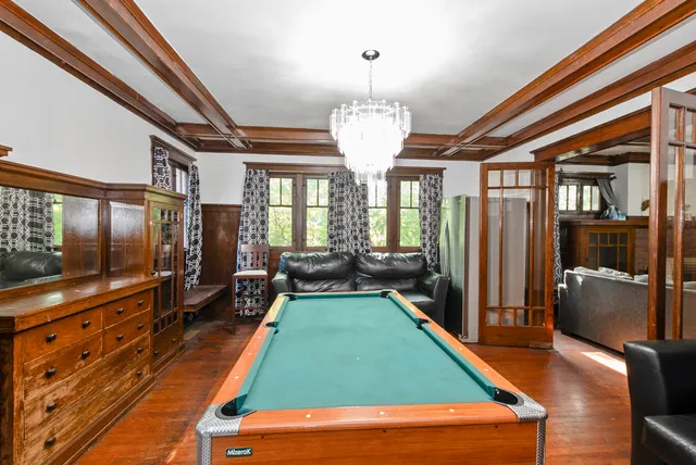 a room with furniture pool table flat screen tv and windows