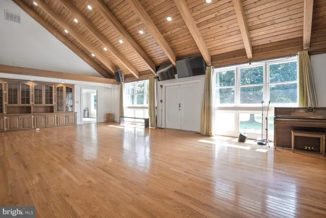 a big room with wooden floors and fireplace