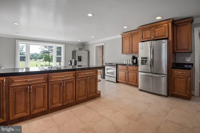 a kitchen with granite countertop stainless steel appliances a refrigerator sink and microwave