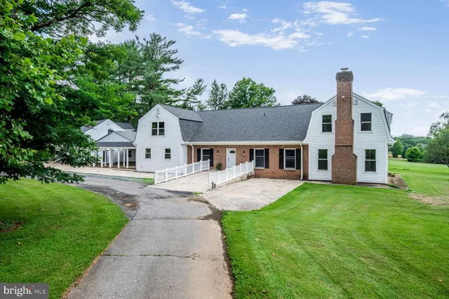 a front view of a house with yard and green space