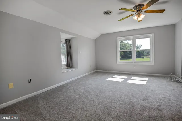 a bathroom with a granite countertop sink a toilet a mirror and shower