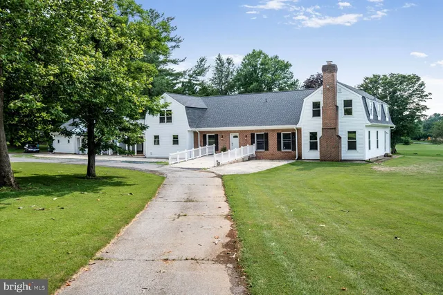 a front view of a house with a yard and trees