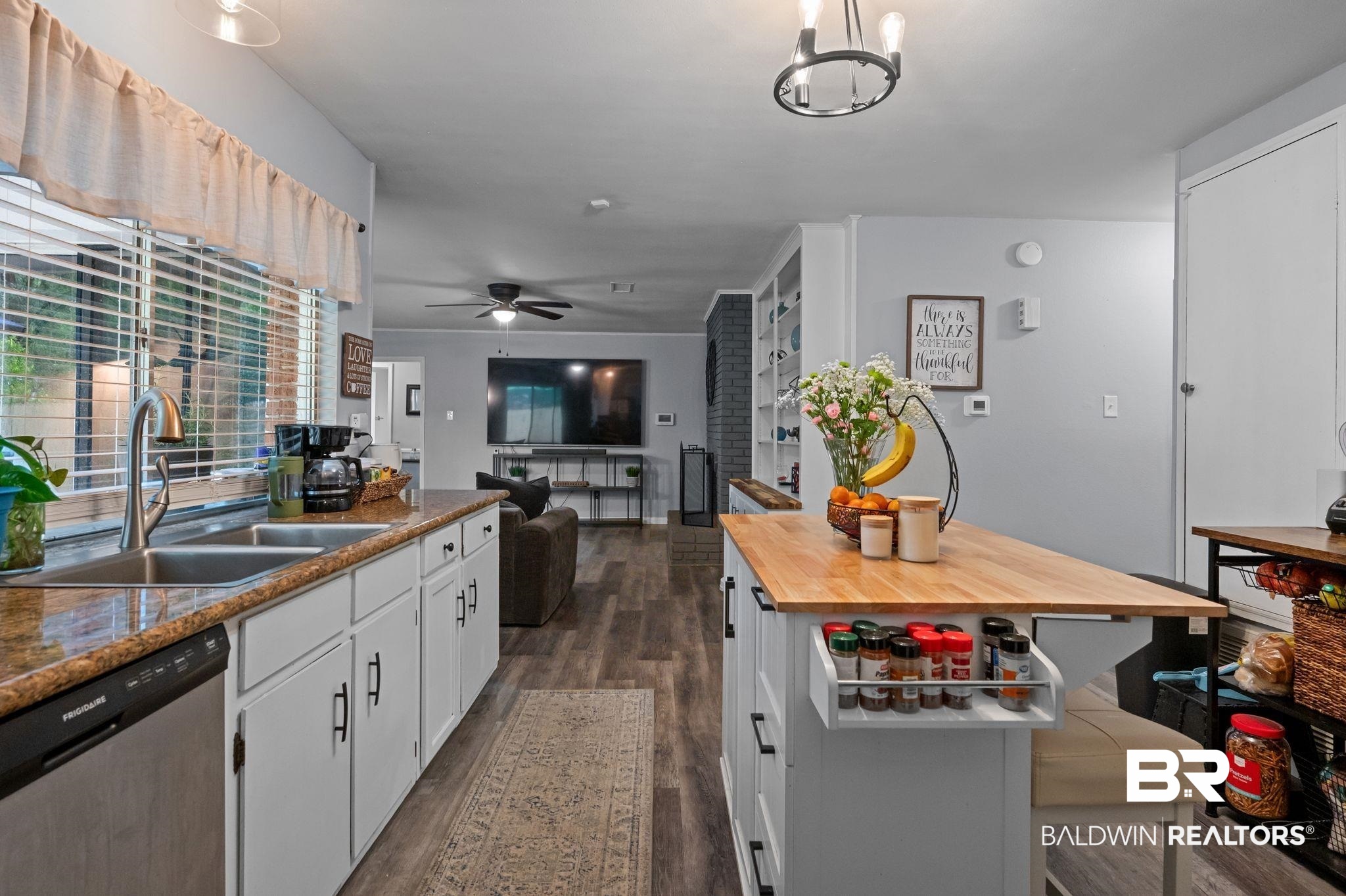 4724 Wicker Way Mobile, AL 36609 - Photo 10 of 36 Bright kitchen featuring white cabinetry with dark hardware, a double basin sink, and wood-finish flooring
