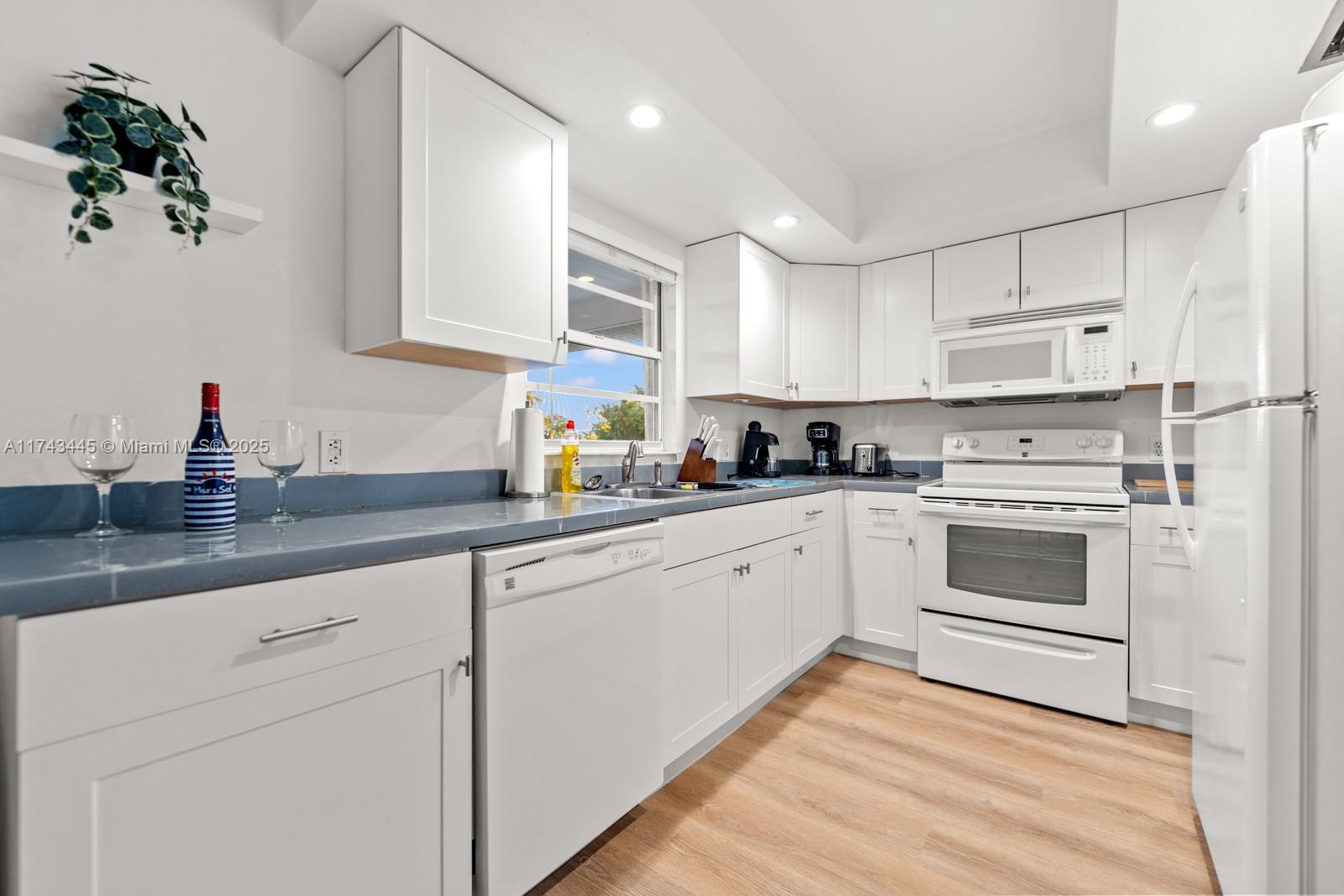 3635 Tradewinds Street Big Pine Key, FL 33043 - Photo 24 of 41 a kitchen with granite countertop white cabinets and white appliances