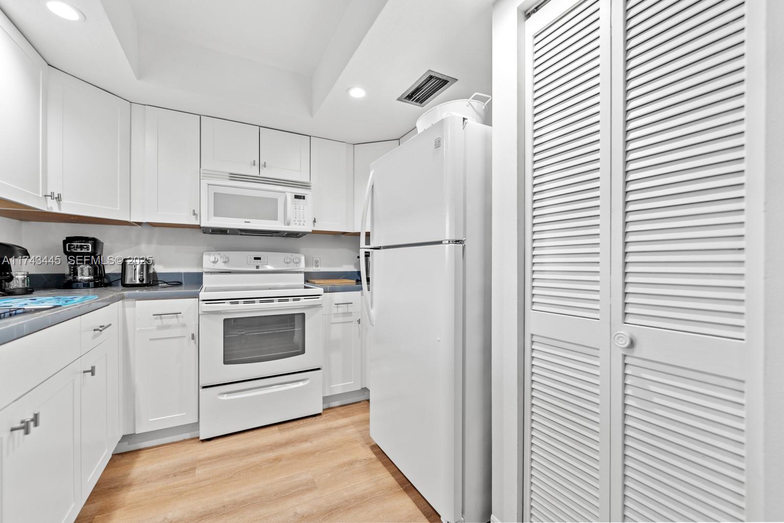 3635 Tradewinds Street Big Pine Key, FL 33043 - Photo 25 of 41 a kitchen with white cabinets and white appliances