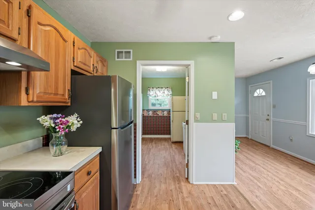 a kitchen with refrigerator cabinets and wooden floor