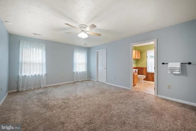 a view of empty room with window and ceiling fan