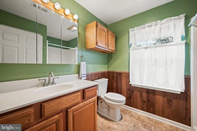 a bathroom with a sink a toilet and mirror