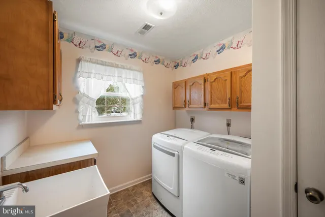 a utility room with cabinets washer and dryer