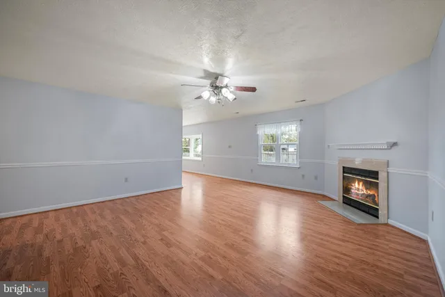 an empty room with windows and fireplace