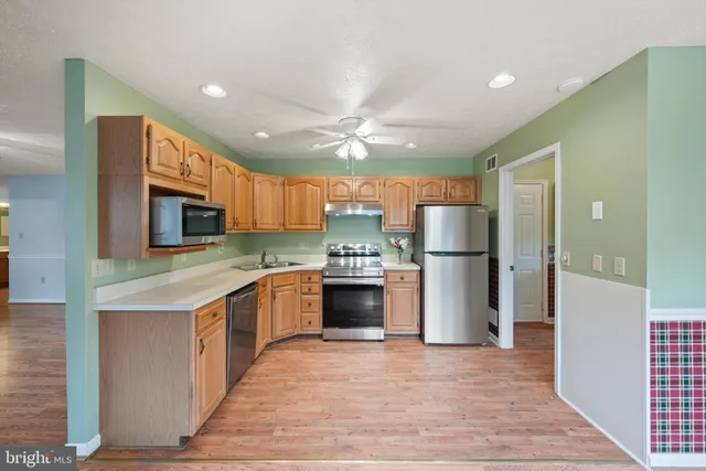 a kitchen with stainless steel appliances granite countertop a refrigerator oven a sink and dishwasher