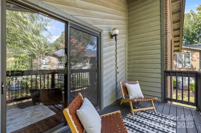 a balcony with wooden floor and outdoor seating