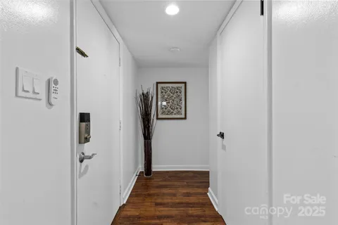 a view of a hallway with wooden floor and closet