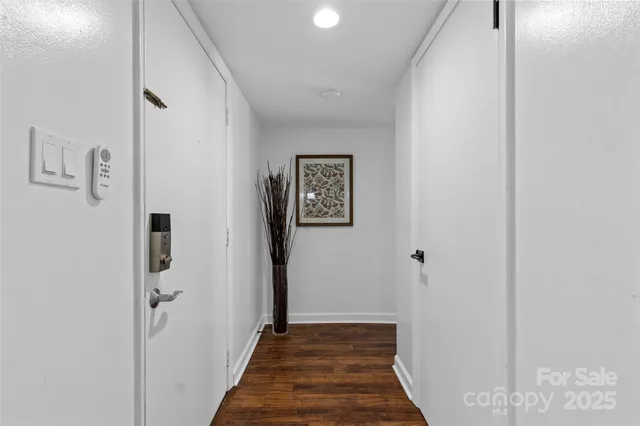 a view of a hallway with wooden floor and closet