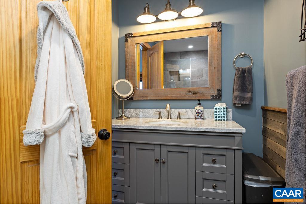134 Squirrel Tree Lane Roseland, VA 22967 - Photo 31 of 40 a bathroom with a granite countertop sink and a mirror
