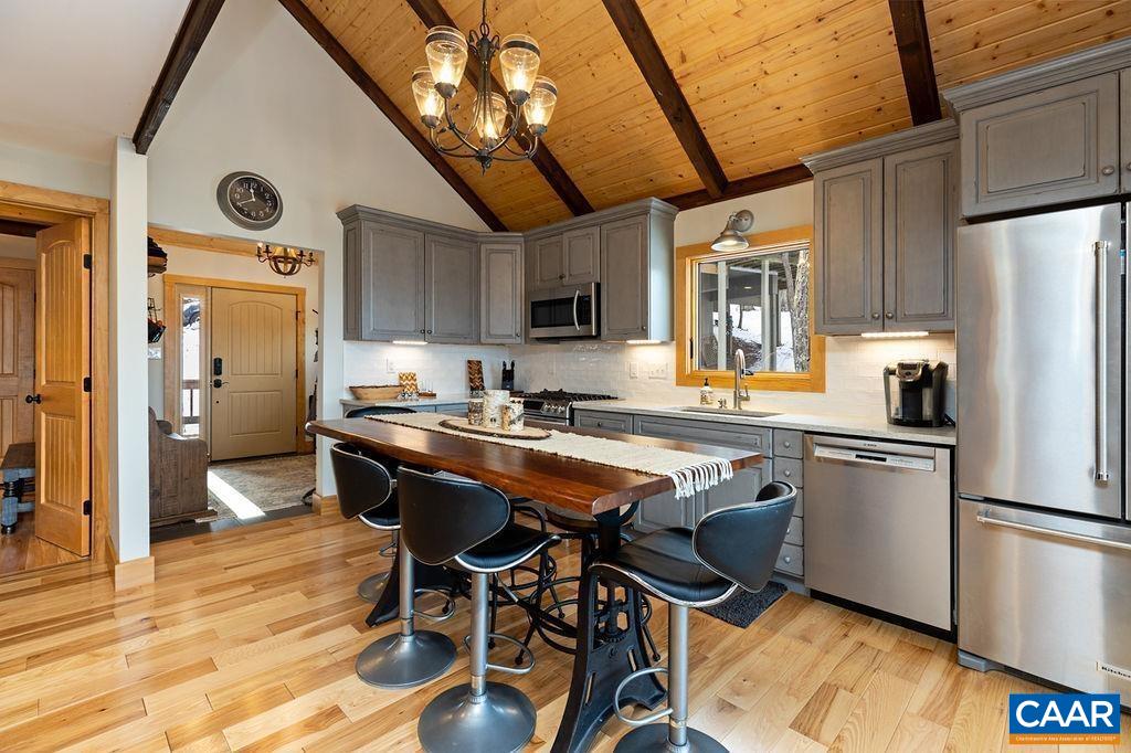 134 Squirrel Tree Lane Roseland, VA 22967 - Photo 5 of 40 a kitchen with granite countertop a refrigerator a stove a sink and white cabinets with wooden floor